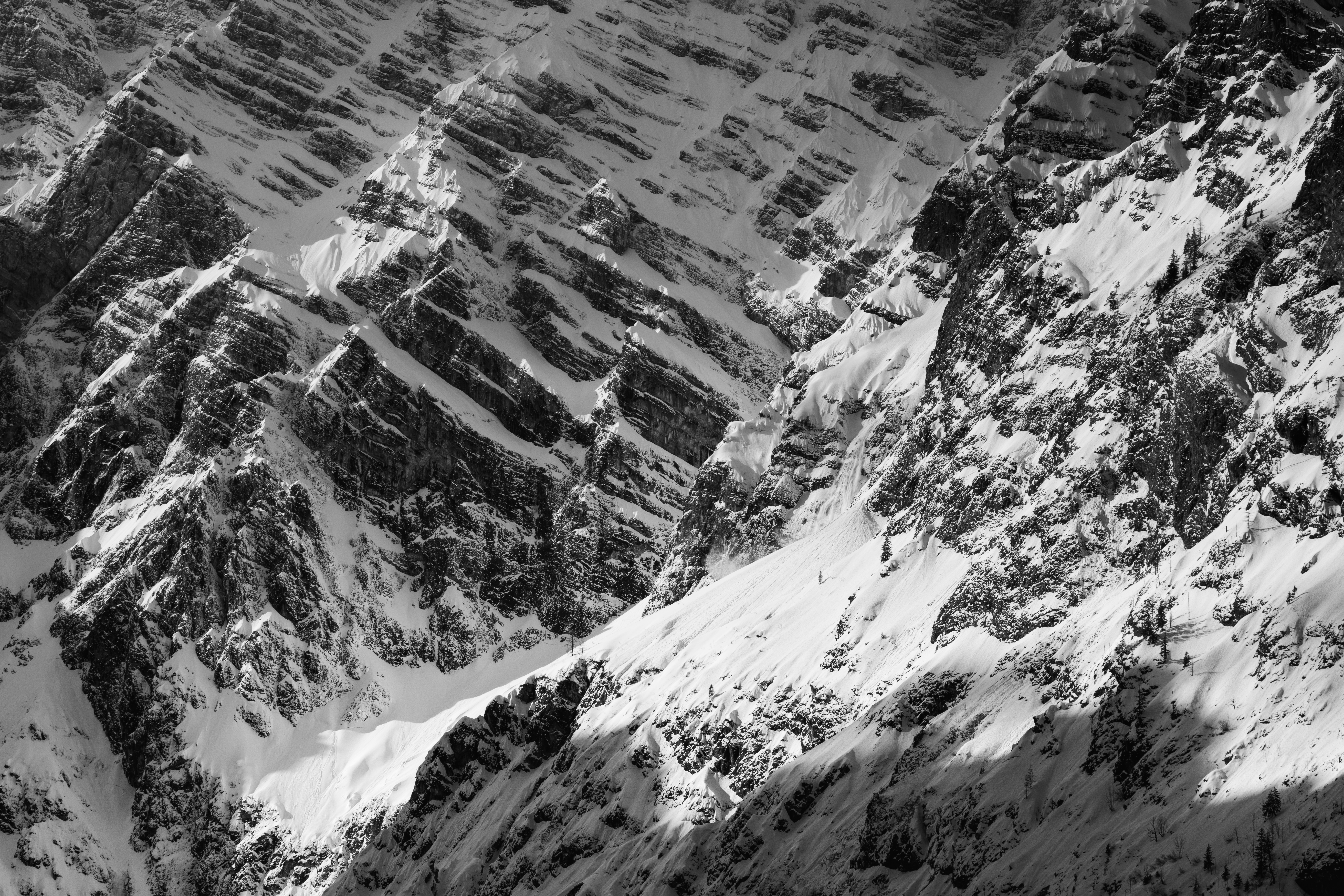 Snow-covered slopes of the Watzmann mountain in Berchtesgadener Land, captured on 3 February 2022. The black-and-white composition highlights the dramatic winter landscape, with rugged rock formations and deep shadows accentuating the mountain’s texture.